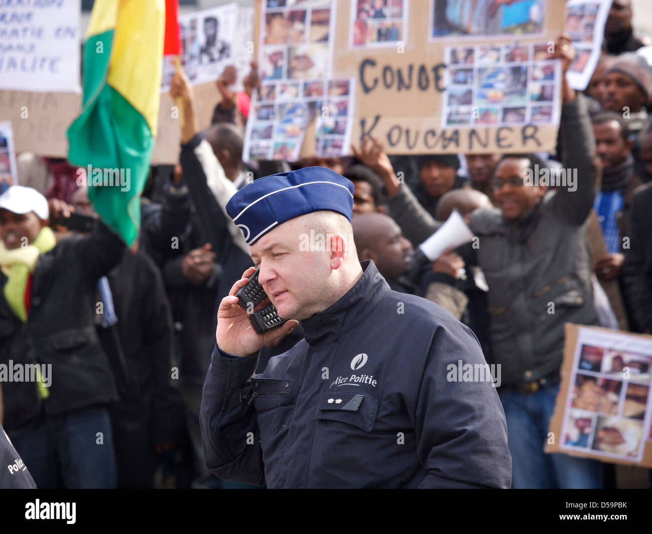 Belgian policeman using two mobile phones at the same time, Brussels, Belgium Stock Photo