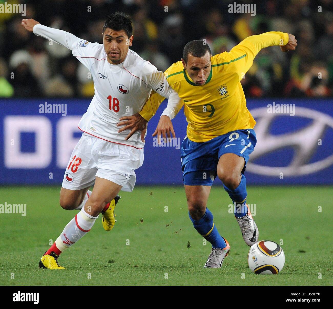 Brazil's Luis Fabiano (R) vies for the ball with Chile's Gonzalo Jara during the 2010 FIFA World Cup Round of Sixteen match between Brazil and Chile at the Ellis Park Stadium in Johannesburg, South Africa 28 June 2010. Photo: Marcus Brandt dpa - Please refer to http://dpaq.de/FIFA-WM2010-TC Stock Photo