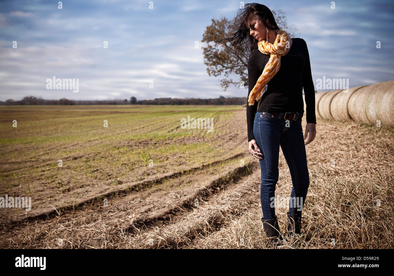 Dark hair woman girl standing in open countryside field Stock Photo