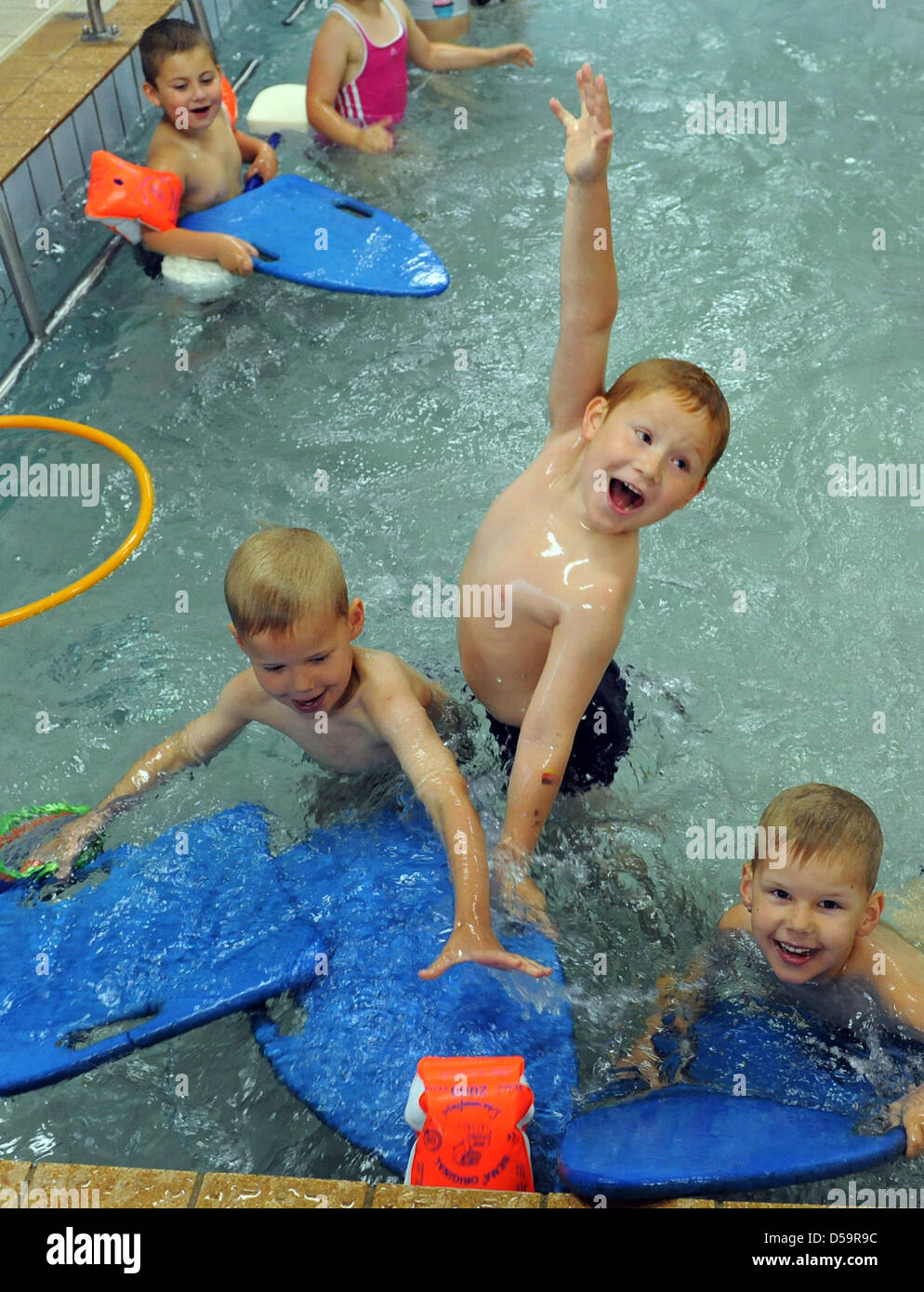 Children have fun with their educator at the in-house swimming pool of day-care centre 'Am Rodelberg' in Torgau, Germany, 23 June 2010. Once a week, the three to nine-years-old children can experience and get used to water and swimming at water temperatures of 27 degrees Celsius. Photo: Waltraud Grubitzsch Stock Photo