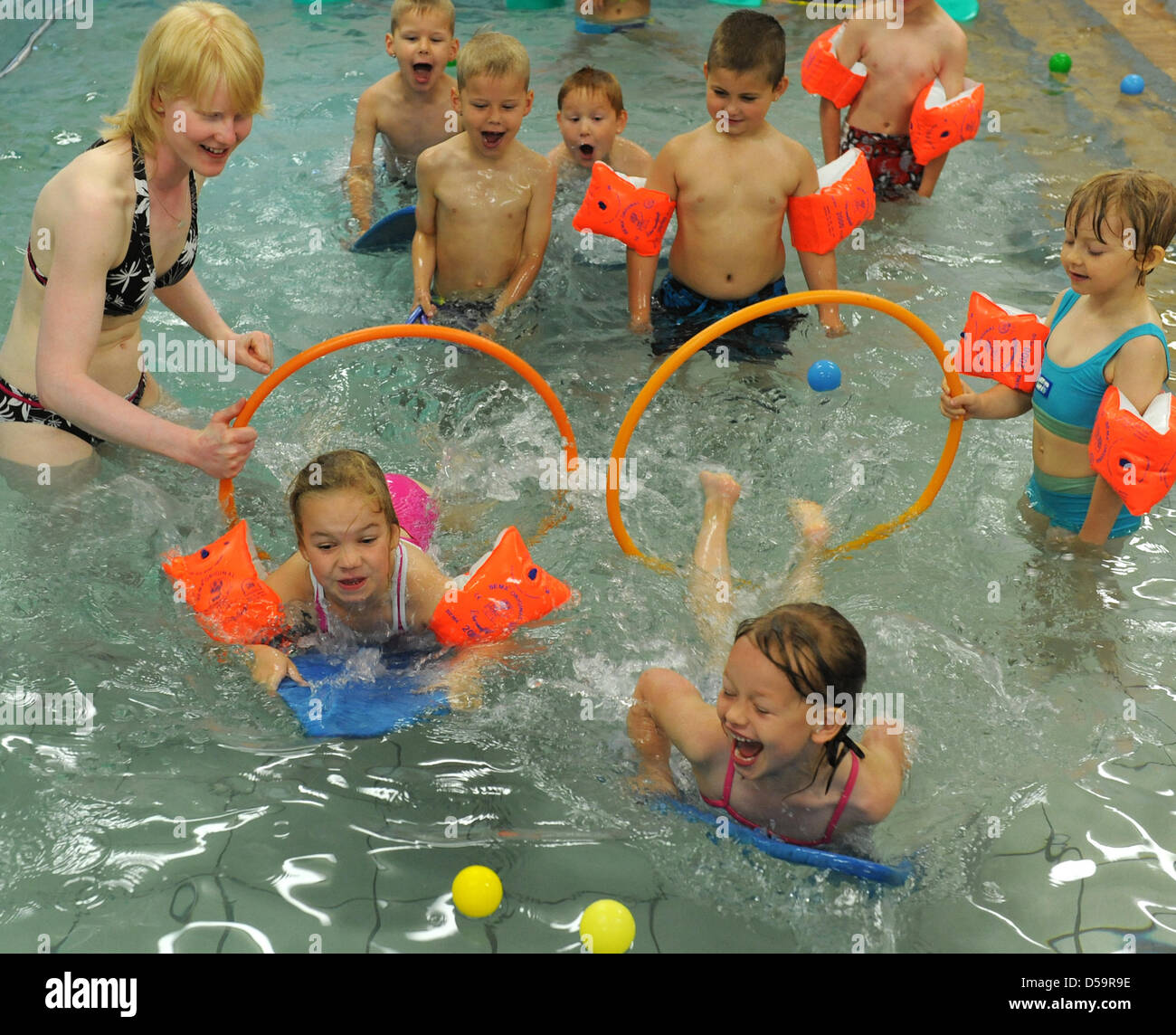Children have fun with their educator at the in-house swimming pool of day-care centre 'Am Rodelberg' ub Torgau, Germany, 23 June 2010. Once a week, the three to nine-years-old children can experience and get used to water and swimming at water temperatures of 27 degrees Celsius. Photo: Waltraud Grubitzsch Stock Photo