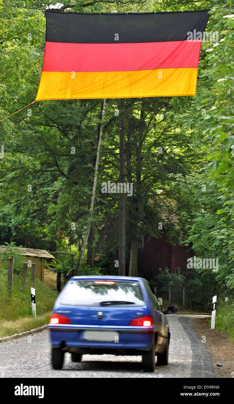 A German flag is placed between trees above a small street in Jocketa (Vogtland), Germany, 01 July 2010. The german national team will challenge Argentina in the quarter-finals of the Soccer World Cup, South Africa, on 03 July 2010. Photo Jan Woitas/Isn Stock Photo