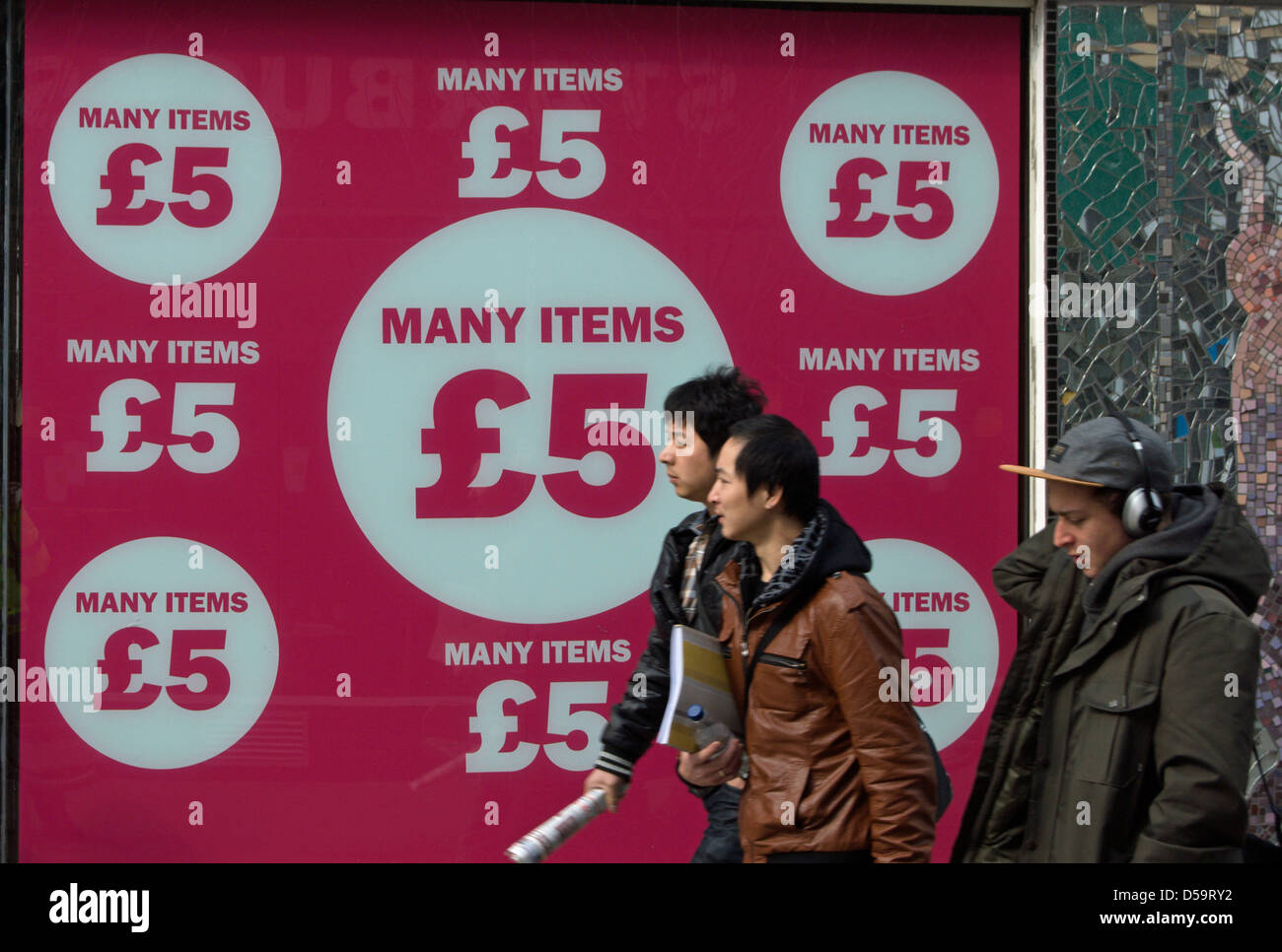 pedestrians pass a shop window display advertising items at £5  kingston upon thames, surrey, england Stock Photo