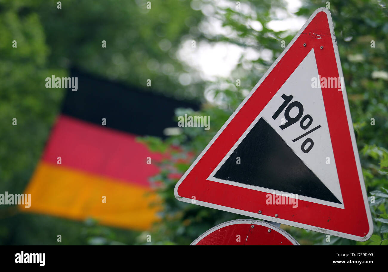 A roadsign indicates a 19% gradient with a German flag in the background, picture taken in Jocketa, Germany on 1 July 2010. After the presidental election, the black and yellow coalition formed by the Christian Democratic Union and the Liberal party announced that they will reconsider the disputed value-added tax rates. Especially the reduction of the VAT on hotel overnight stays f Stock Photo