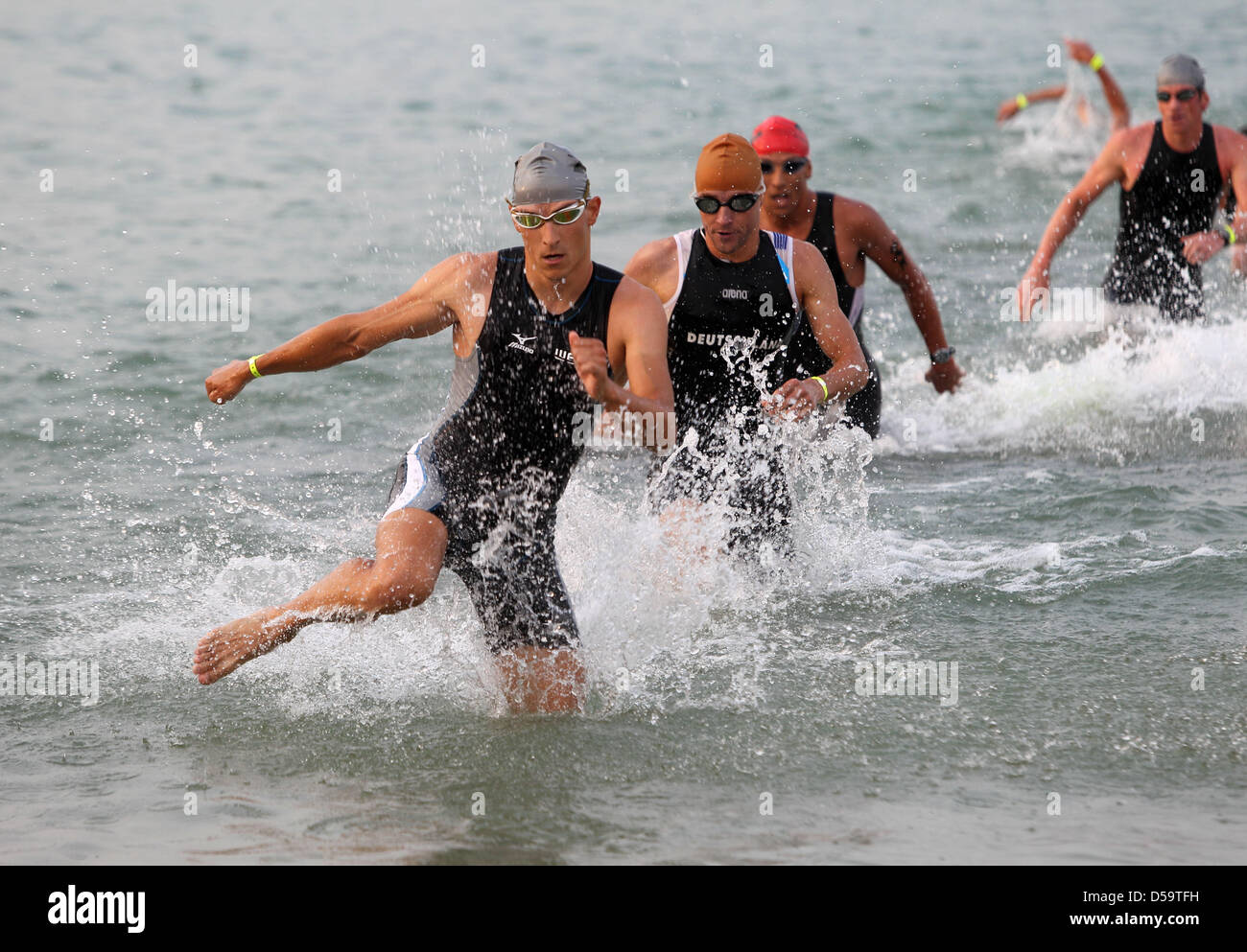 German triathletes Carsten Ritter and Andreas Raeltert rush out of the water during a swimming passage of the Ironman Europe in Frankfurt, Germany on 4. July 2010. More than 2300 triathletes from 55 nations take part in the turnament, which includes 3,8km of swimming, 180km of cycling and a concluding 42,2 km long marathon. Photo: Thomas Frey dpa/Ihe Stock Photo