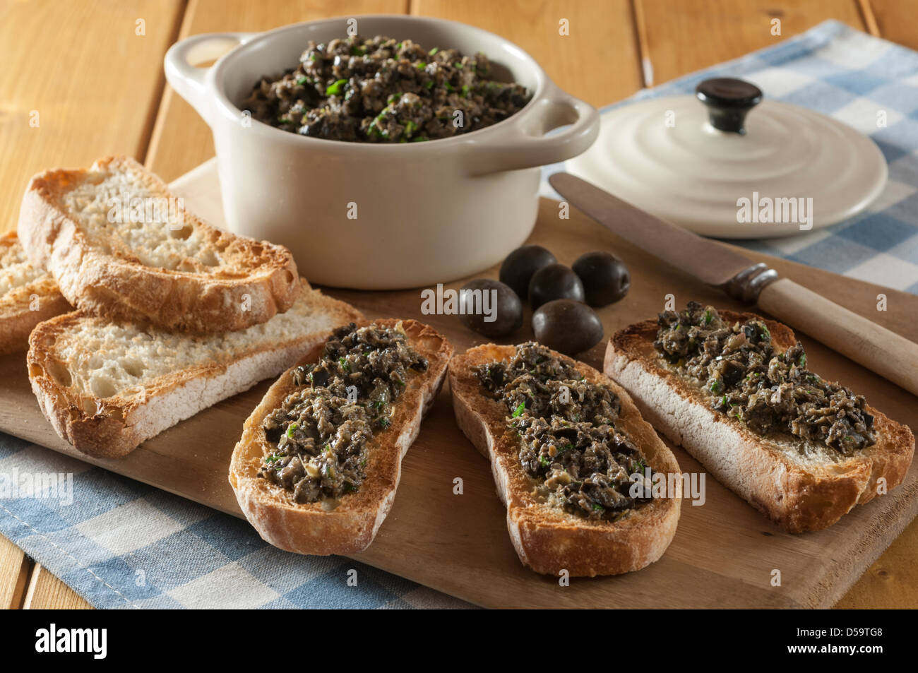 Black olive tapenade on toasted french bread Stock Photo
