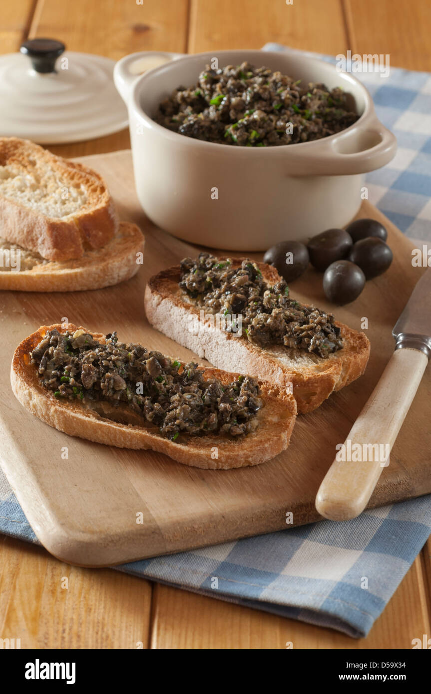 Black olive tapenade on toasted french bread Stock Photo