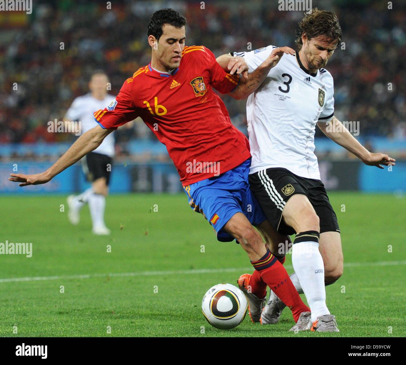 Arne Friedrich (R) of Germany vies with Sergio Busquets of Spain during the 2010 FIFA World Cup semi-final match between Germany and Spain at the Durban Stadium in Durban, South Africa 07 July 2010. Photo: Bernd Weissbrod dpa - Please refer to http://dpaq.de/FIFA-WM2010-TC  +++(c) dpa - Bildfunk+++ Stock Photo