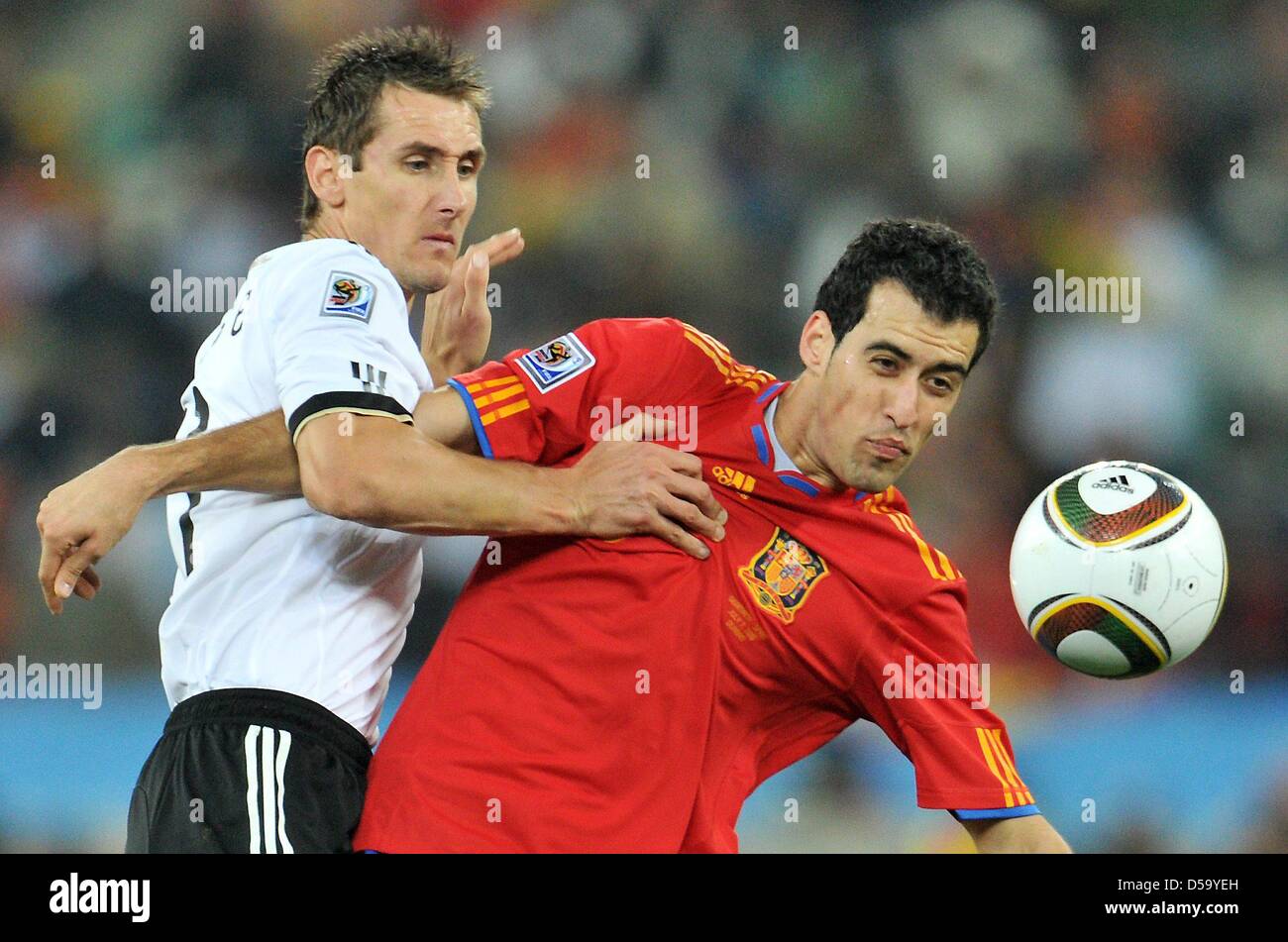 Miroslav Klose (L) of Germany vies with Sergio Busquets of Spain during the 2010 FIFA World Cup semi-final match between Germany and Spain at the Durban Stadium in Durban, South Africa 07 July 2010. Photo: Bernd Weissbrod dpa - Please refer to http://dpaq.de/FIFA-WM2010-TC  +++(c) dpa - Bildfunk+++ Stock Photo