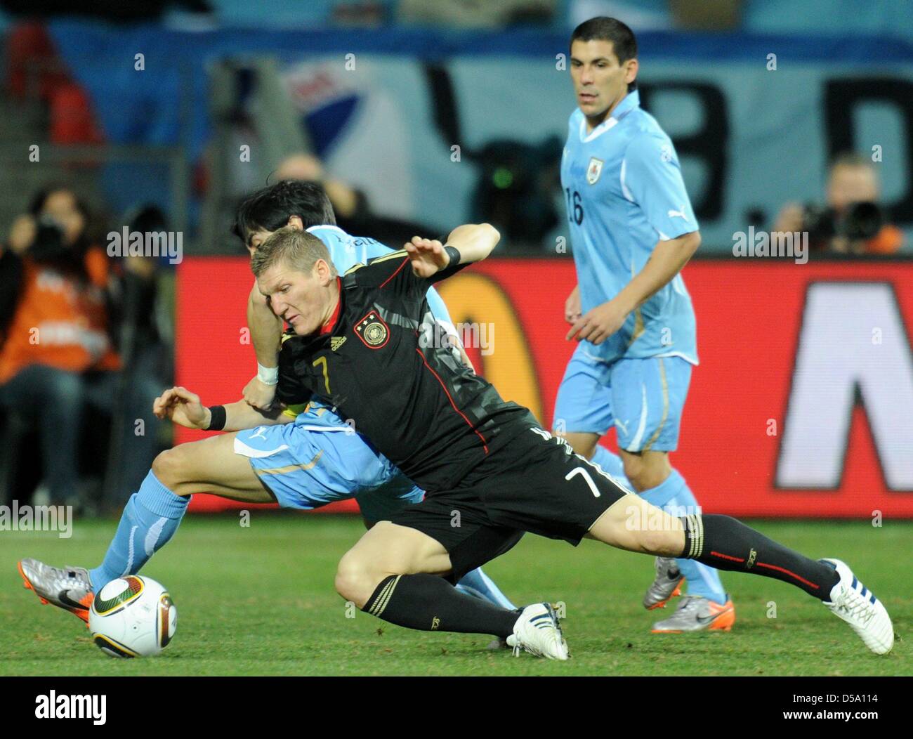Jorge Fucile (L) of Uruguay vies with Bastian Schweinsteiger of Germany (C) during the 2010 FIFA World Cup third place match between Uruguay and Germany at the Nelson Mandela Bay Stadium in Port Elizabeth, South Africa 10 July 2010. Photo: Bernd Weissbrod dpa - Please refer to http://dpaq.de/FIFA-WM2010-TC  +++(c) dpa - Bildfunk+++ Stock Photo