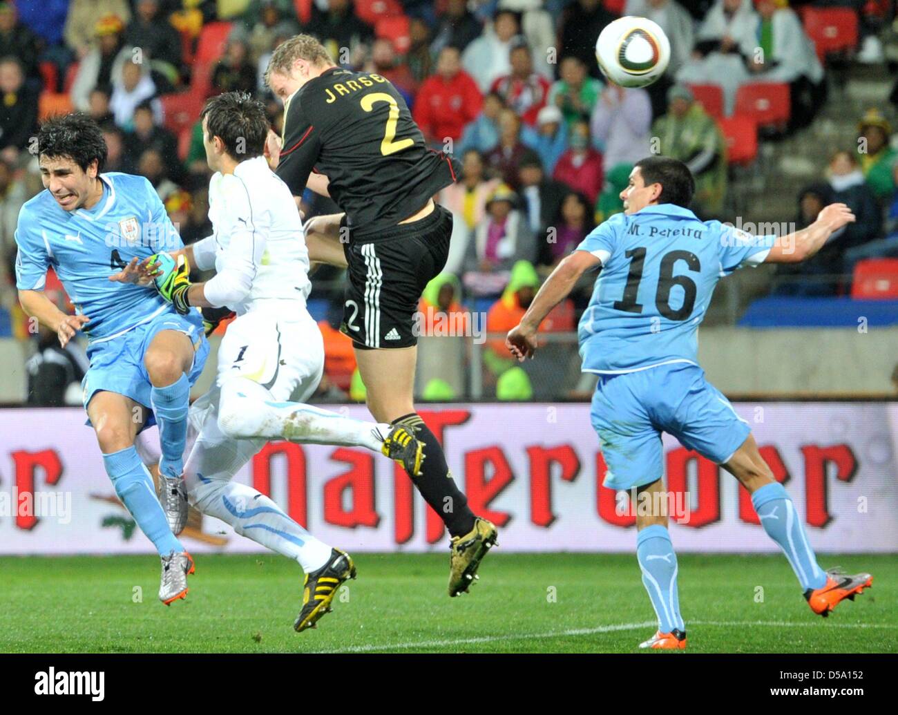 Marcell Jansen (2-R) of Germany scores against Jorge Fucile (L-R), goalkeeper Fernando Muslera and Maximilano Perez during the 2010 FIFA World Cup third place match between Uruguay and Germany at the Nelson Mandela Bay Stadium in Port Elizabeth, South Africa 10 July 2010. Photo: Bernd Weissbrod dpa - Please refer to http://dpaq.de/FIFA-WM2010-TC  +++(c) dpa - Bildfunk+++ Stock Photo