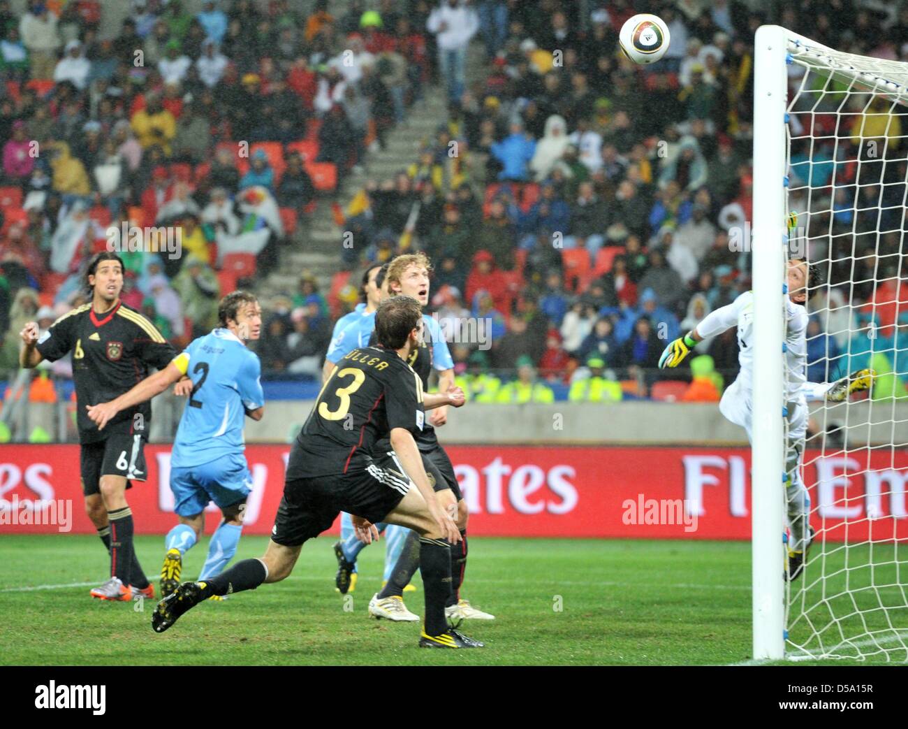 Sami Khedira (L) of Germany scores against goalkeeper Fernando Muslera (R) of Uruguay the 3-2 during the 2010 FIFA World Cup third place match between Uruguay and Germany at the Nelson Mandela Bay Stadium in Port Elizabeth, South Africa 10 July 2010. Photo: Bernd Weissbrod dpa - Please refer to http://dpaq.de/FIFA-WM2010-TC  +++(c) dpa - Bildfunk+++ Stock Photo