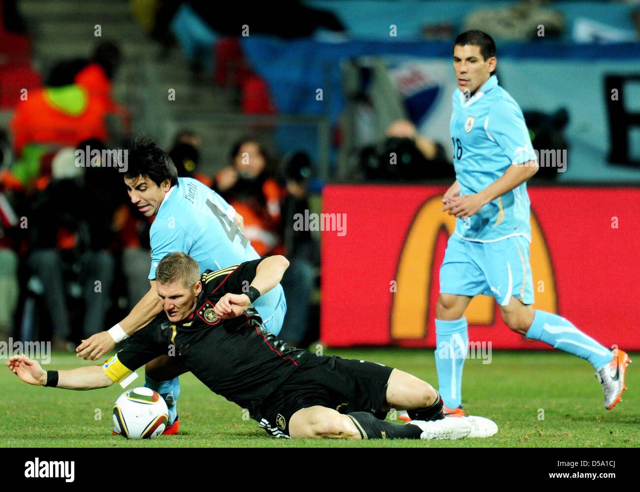 Jorge Fucile (L) of Uruguay vies with Bastian Schweinsteiger of Germany during the 2010 FIFA World Cup third place match between Uruguay and Germany at the Nelson Mandela Bay Stadium in Port Elizabeth, South Africa 10 July 2010. Photo: Bernd Weissbrod dpa - Please refer to http://dpaq.de/FIFA-WM2010-TC Stock Photo