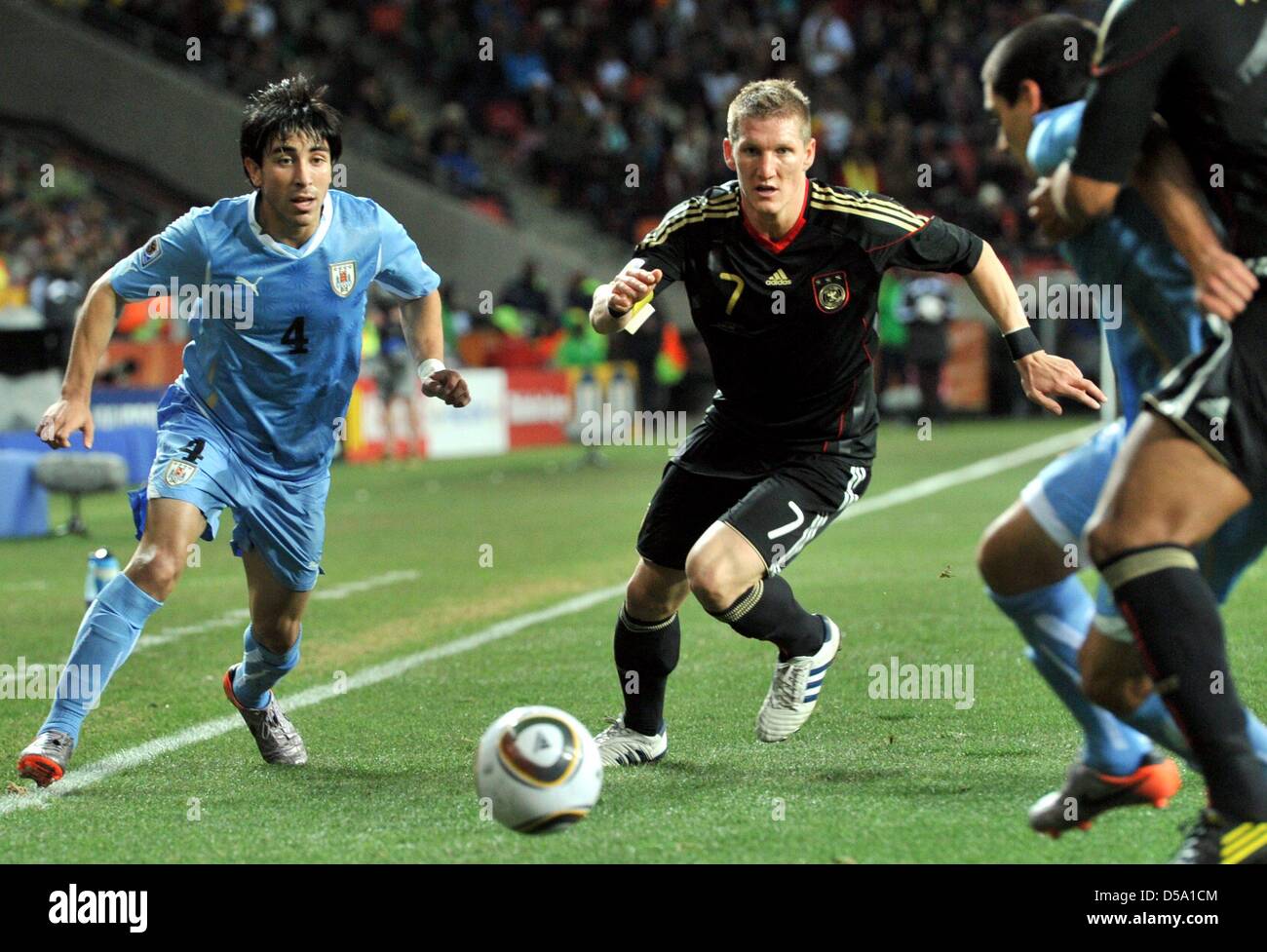 Jorge Fucile (L) of Uruguay vies with Bastian Schweinsteiger (C) of Germany during the 2010 FIFA World Cup third place match between Uruguay and Germany at the Nelson Mandela Bay Stadium in Port Elizabeth, South Africa 10 July 2010. Photo: Bernd Weissbrod dpa - Please refer to http://dpaq.de/FIFA-WM2010-TC Stock Photo