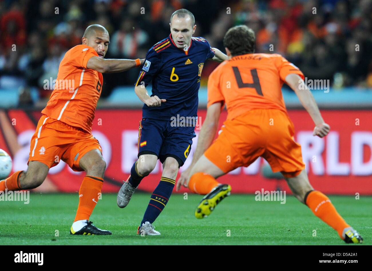 Andres Iniesta (C) of Spain vies with Nigel de Jong (L) and Joris Mathijsen (R) of the Netherlands during the 2010 FIFA World Cup final match between the Netherlands and Spain at the Soccer City Stadium in Johannesburg, South Africa 11 July 2010. Photo: Bernd Weissbrod dpa - Please refer to http://dpaq.de/FIFA-WM2010-TC  +++(c) dpa - Bildfunk+++ Stock Photo