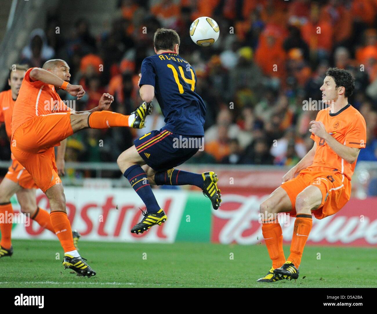 Dutch Nigel de Jong (L) fouls Spain's Xabi Alonso as Dutch Mark van Bommel looks on during the 2010 FIFA World Cup final match between the Netherlands and Spain at Soccer City Stadium in Johannesburg, South Africa 11 July 2010. Photo: Marcus Brandt dpa - Please refer to http://dpaq.de/FIFA-WM2010-TC  +++(c) dpa - Bildfunk+++ Stock Photo