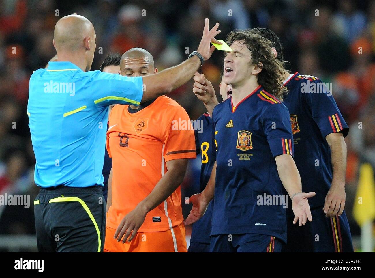 Dutch Nigel de Jong (C) and Spain's Carles Puyol argue with English referee Howard Webb during the 2010 FIFA World Cup final match between the Netherlands and Spain at Soccer City Stadium in Johannesburg, South Africa 11 July 2010. Photo: Marcus Brandt dpa - Please refer to http://dpaq.de/FIFA-WM2010-TC  +++(c) dpa - Bildfunk+++ Stock Photo