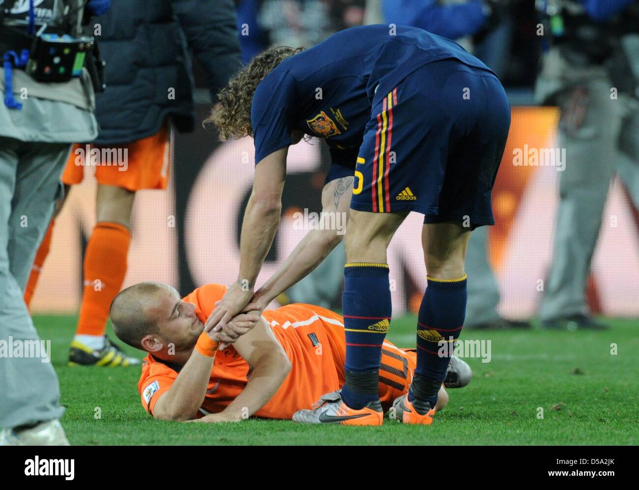 Dutch Wesley Sneijder is helped up by Spain's Carles Puyol after the 2010 FIFA World Cup final match between the Netherlands and Spain at Soccer City Stadium in Johannesburg, South Africa 11 July 2010. Photo: Marcus Brandt dpa - Please refer to http://dpaq.de/FIFA-WM2010-TC  +++(c) dpa - Bildfunk+++ Stock Photo