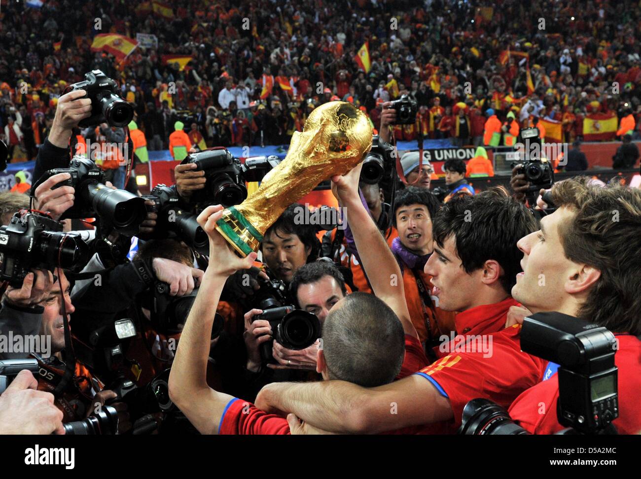 Andres Iniesta (C) of Spain celebrates with the trophy after the 2010 FIFA World Cup final match between the Netherlands and Spain at the Soccer City Stadium in Johannesburg, South Africa 11 July 2010. Photo: Bernd Weissbrod dpa - Please refer to http://dpaq.de/FIFA-WM2010-TC  +++(c) dpa - Bildfunk+++ Stock Photo