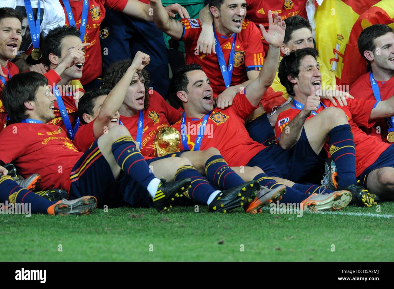 Spain's Carles Puyol (C) and Xavi (CR) celebrate with the World Cup trophy after the 2010 FIFA World Cup final match between the Netherlands and Spain at Soccer City Stadium in Johannesburg, South Africa 11 July 2010. Photo: Marcus Brandt dpa - Please refer to http://dpaq.de/FIFA-WM2010-TC  +++(c) dpa - Bildfunk+++ Stock Photo