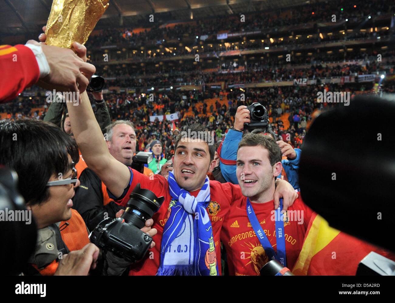 David Villa (L) and Juan Manuel Mata of Spain celebrate with the trophy after the 2010 FIFA World Cup final match between the Netherlands and Spain at the Soccer City Stadium in Johannesburg, South Africa 11 July 2010. Photo: Bernd Weissbrod dpa - Please refer to http://dpaq.de/FIFA-WM2010-TC  +++(c) dpa - Bildfunk+++ Stock Photo