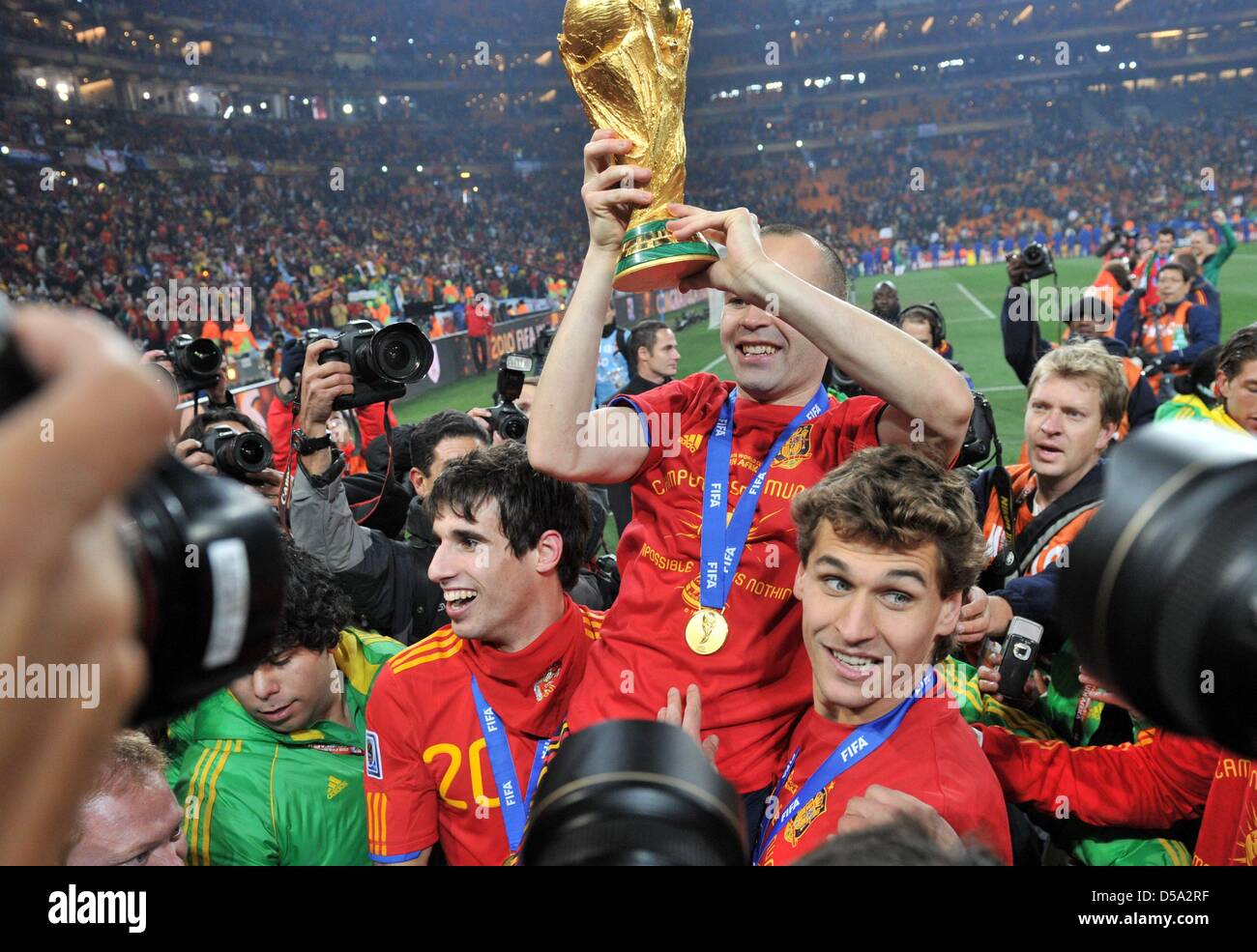 Andres Iniesta (C) of Spain celebrates with the trophy of the 2010 FIFA World Cup final match between the Netherlands and Spain at the Soccer City Stadium in Johannesburg, South Africa 11 July 2010. Photo: Bernd Weissbrod dpa - Please refer to http://dpaq.de/FIFA-WM2010-TC  +++(c) dpa - Bildfunk+++ Stock Photo