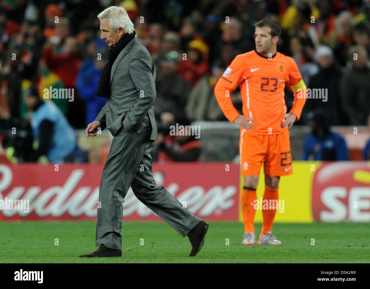 Dutch coach Bert van Marwijk walks over the pitch past player Rafael van  der Vaart after the 2010 FIFA World Cup final match between the Netherlands  and Spain at Soccer City Stadium