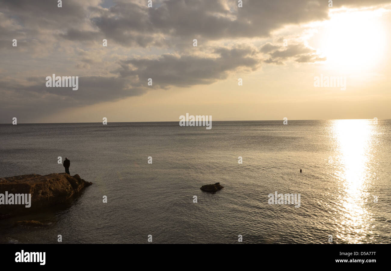 A man watching the sunset of the coast of Athens Stock Photo - Alamy