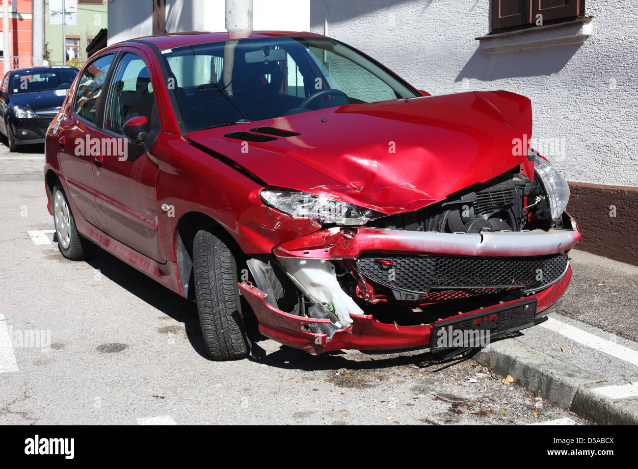 Wrecked red car on the street pavement Stock Photo