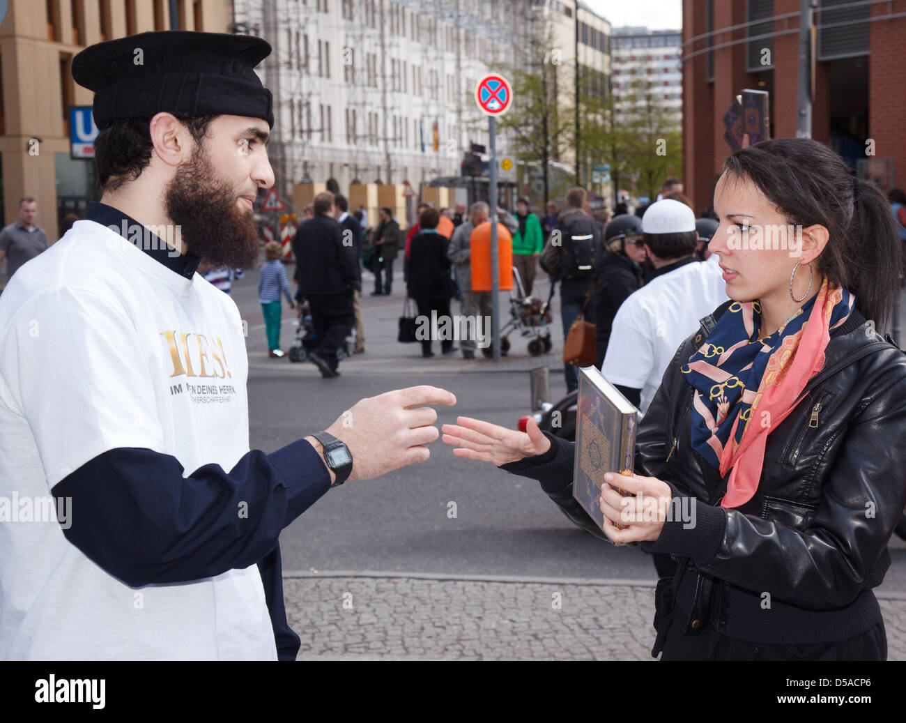 Berlin, Germany, the man reaches over a passer Quran and discussed with her Stock Photo