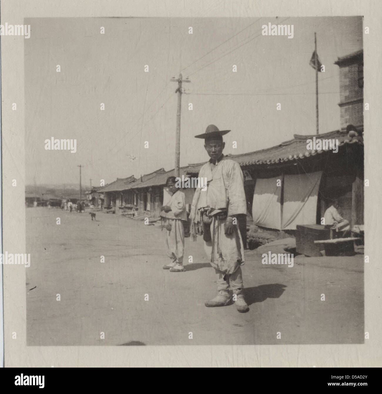 Korean Rural Man A photograph showing a young Korean man and a boy, both likely from a ...