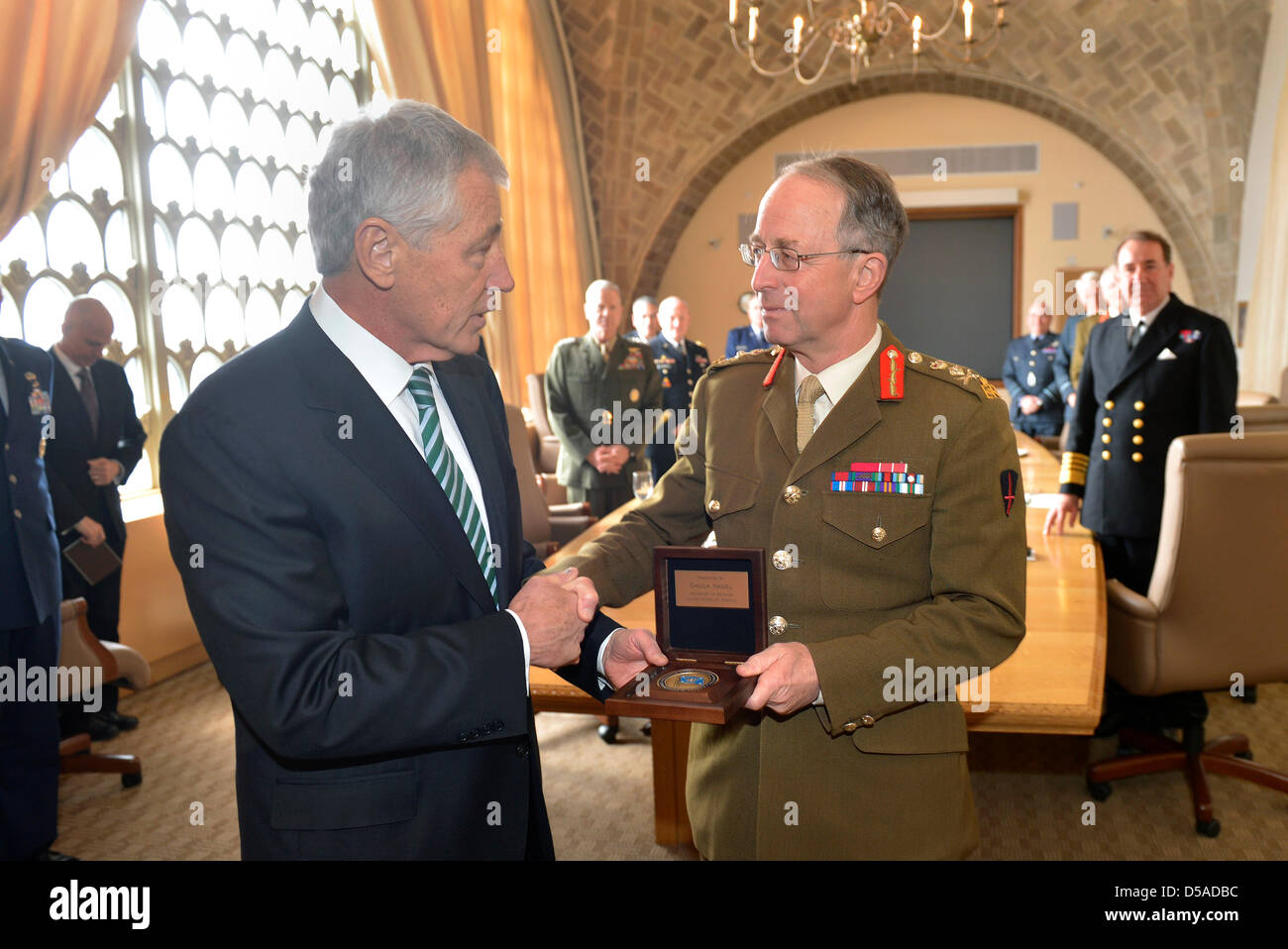 US Secretary of Defense Chuck Hagel presents British Chief of the Defence Staff General David Richards with the Secretary of Defense medallion at the National Defense University at Fort McNair March 27, 2013 in Washington, DC. This is the first meeting of its kind since 1948 and was called to discuss strategic challenges the UK and US militaries may face together in the future. Stock Photo