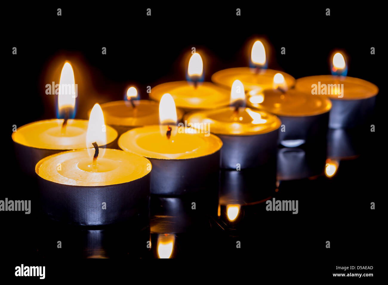 Group of burning candles on black background Stock Photo - Alamy