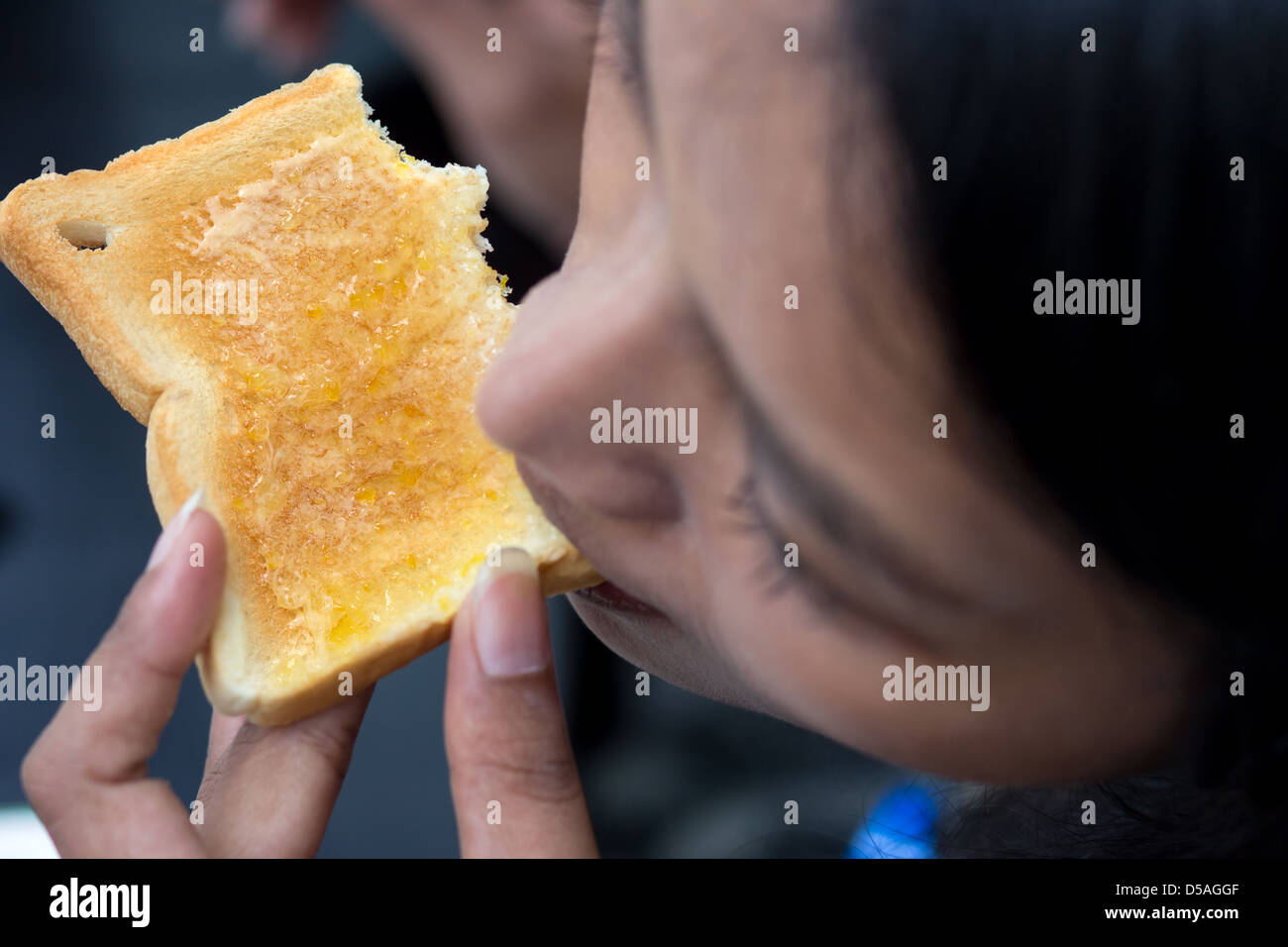 Woman eating toast Stock Photo Alamy