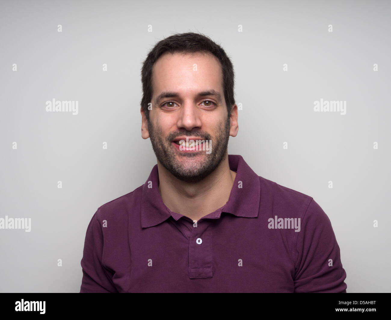 Portrait of a 3-day bearded young man with fake smile Stock Photo