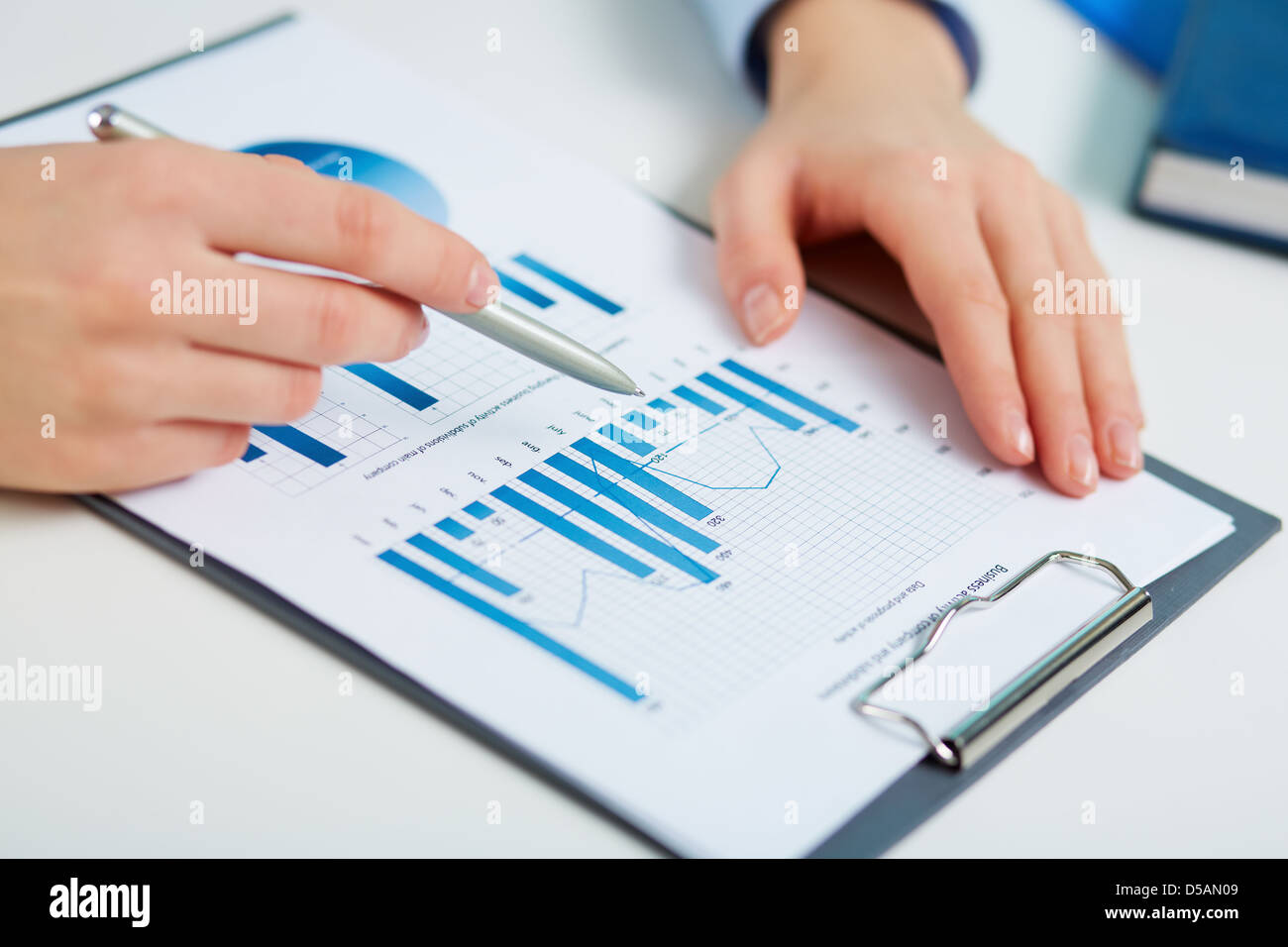 Close-up of printed statistics analyzed by a female business worker Stock Photo