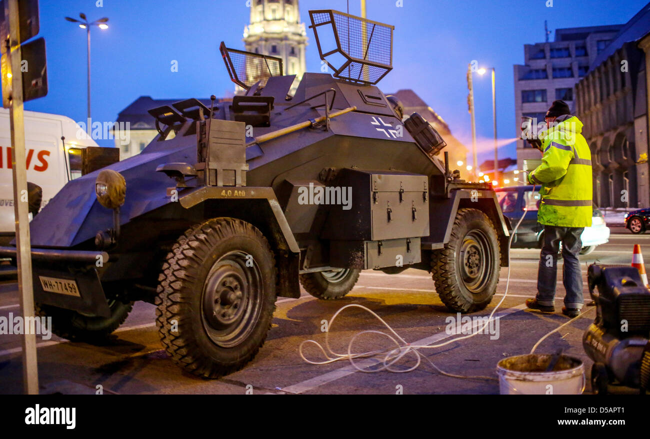 A man spraypaints a type Sd.Kfz. 222 light armoured reconnaissance vehicle of the Wehrmacht which serves as movie-prop at the movie set of 'The Monument Men' by US actor George Clooney in Nicholas' Quarter in Berlin, Germany, 27 March 2013. Photo: Hannibal/dpa Stock Photo