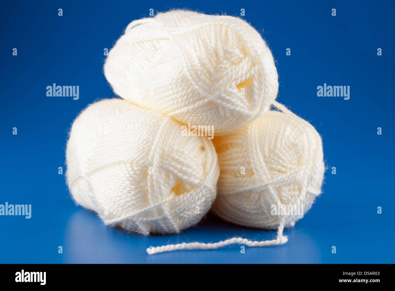 Three balls of 100 gram premium acrylic cream coloured wool Stock Photo