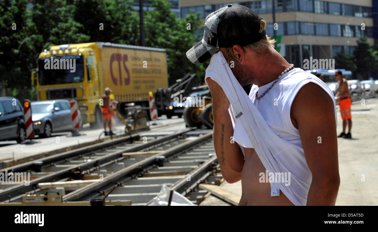 A roadman wipes the sweat off his face in Grillparzer Street at hot ...