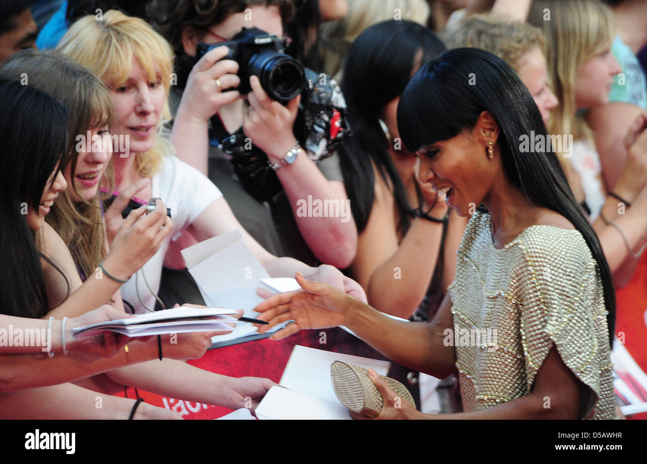 American actor Jada Pinkett Smith (R) signs autographs aon the red carpet at the premier of 'Karate Kid' in Berlin, Germany, 19 July 2010. The film will be shown in German cinemas starting 22 July 2010. Photo: Hannibal Hanschke Stock Photo