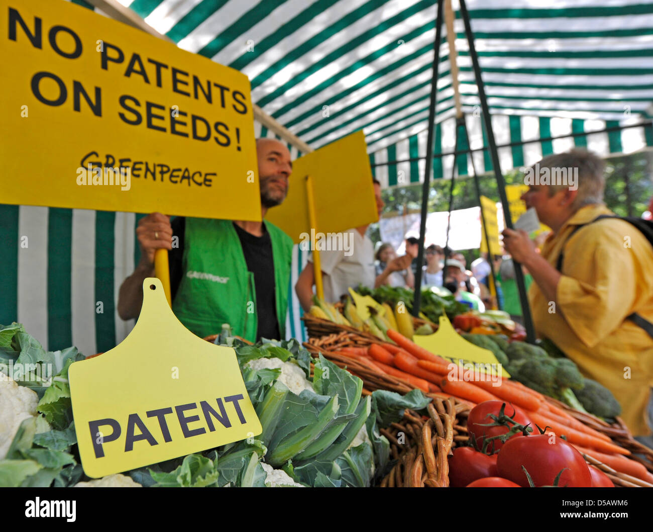 Several Greenpeace activists show signs saying 'No patents on seeds' and 'Keine Patente auf Saatgut' at a vegetable stand in front of the European Patent Office (EPO) in Munich, Germany, 20 July 2010. The British company Plant Bioscience had patented the production of a special variant of Broccoli in 2002. On 20 and 21 July, the EPO's Enlarged Board of Appeal will hear the case. Ph Stock Photo
