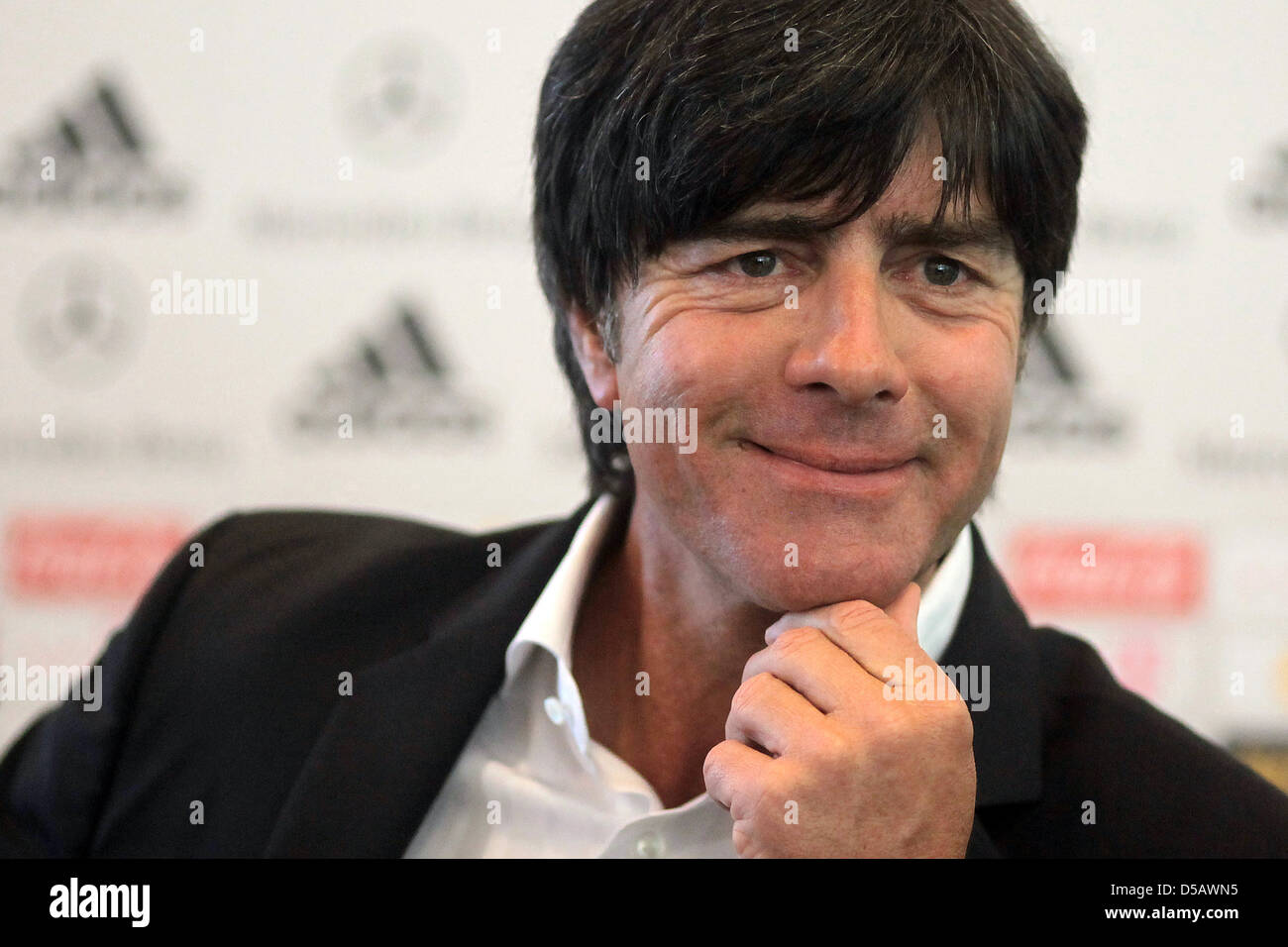 Coach of the German national football team, Joachim Loew, smiles at the headquarters of the DFB in Frankfurt/Main, Germany, 20 July 2010. Oliver Bierhoff, team manager, sits next to Loew. Loew remains coach of the German team. The 50 year-old extended his contract with the DFB until the European Championship in 2012, so did team manager Oliver Bierhoff and the entire coaching staff Stock Photo