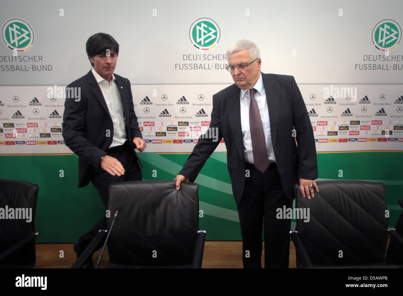 The president of the German football association Theo Zwanziger (R) adjusts a chair for the Coach of the German national football team, Joachim Loew at a press conference at the headquarters of the DFB in Frankfurt/Main, Germany, 20 July 2010. Loew remains coach of the German team. The 50 year-old extended his contract with the DFB until the European Championship in 2012, so did te Stock Photo