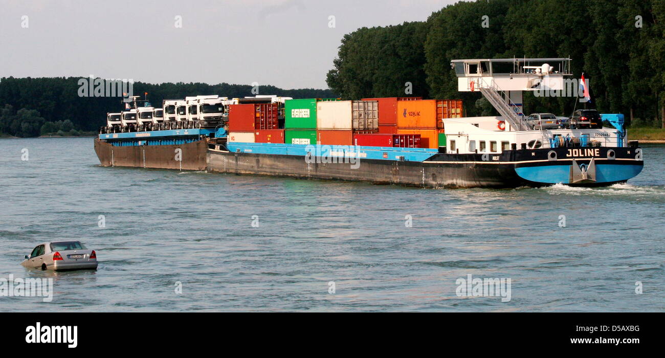 A harbour police handout of a car drfiting on Rhine river as a cargo ship passes near Germersheim, Germany, 21 July 2010. According to police, the car was parked at the banks but not sufficiently secured. It rolled into the river and drifted for a while in the current before it sank. Harbour police locates the car on 22 July, it shopuld be recovered thereafter. Photo: HARBOUR POLIC Stock Photo