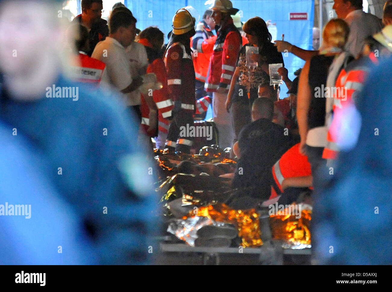 Rescue workers tace care of the injured at the tunnel that was the site of a mass panic that cost 19 lives at the 2010 Love Parade in Duisburg, Germany, 24 July 2010. At least 45 more people have been injured. An estimated million people visited the techno music festival. Photo: Achim Scheidemann Stock Photo