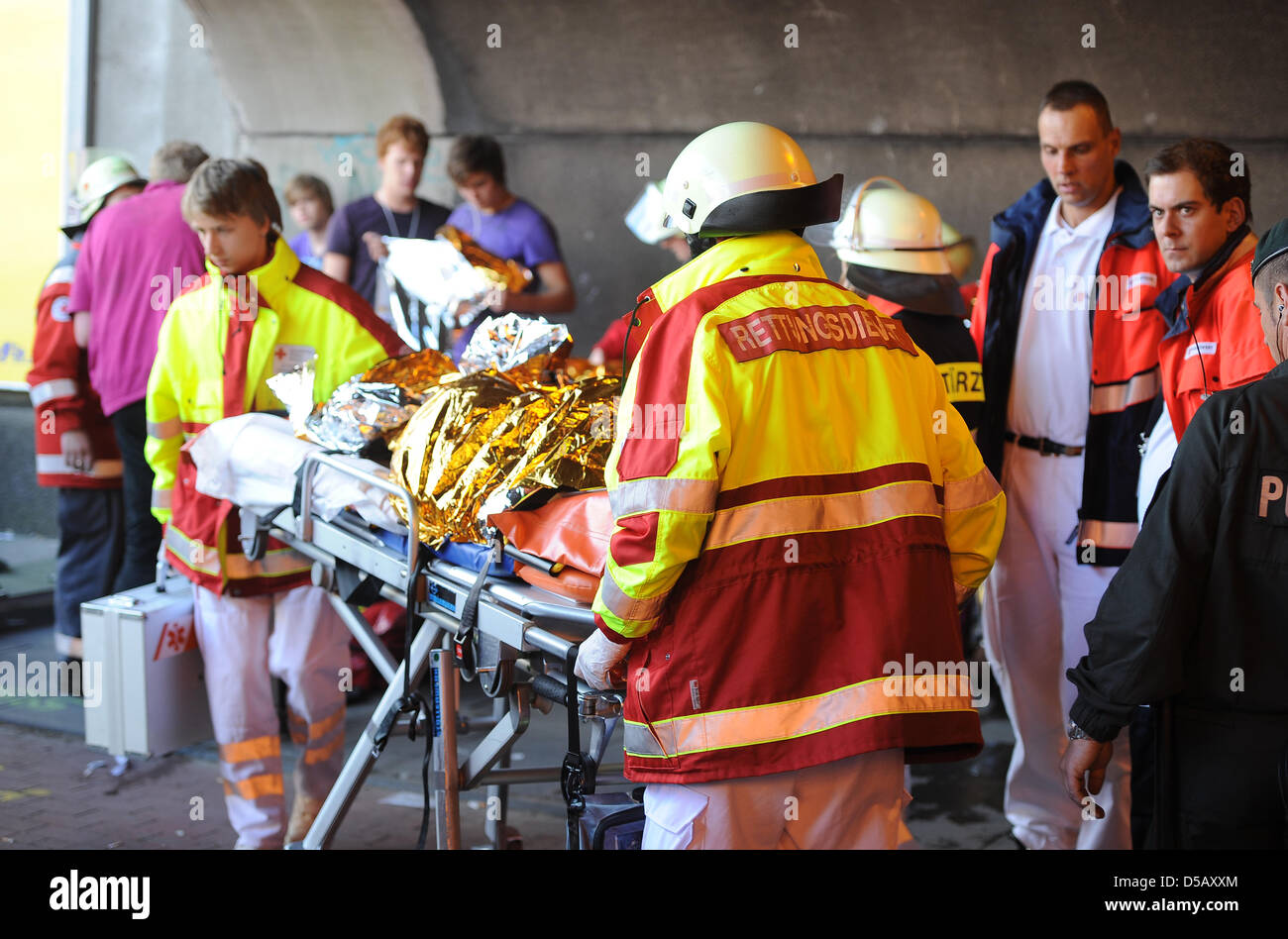 Rescue workers tace care of the injured at the tunnel that was the site of a mass panic that cost 19 lives at the 2010 Love Parade in Duisburg, Germany, 24 July 2010. At least 45 more people have been injured. An estimated million people visited the techno music festival. Photo: Achim Scheidemann Stock Photo