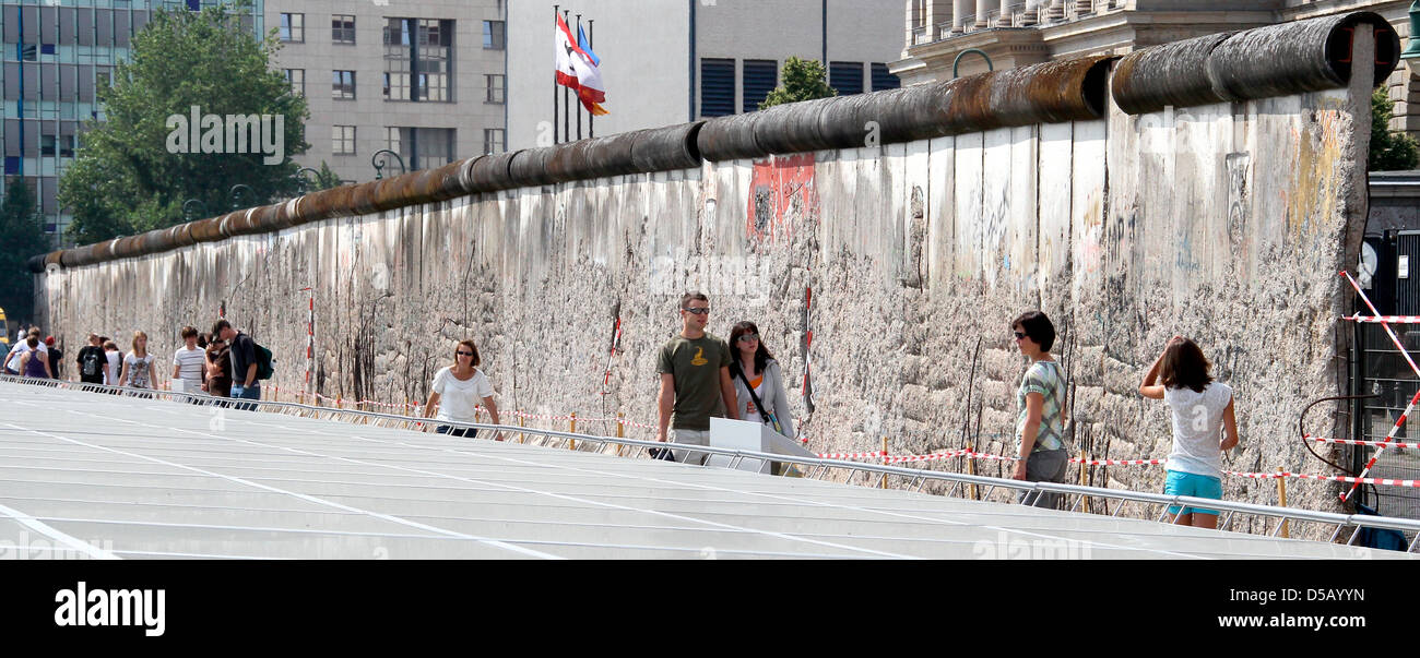 Tourists walk alongside parts of the Berlin Wall on the grounds of the former headquarters of the German Third Reich Secret Police 'Gestapo' which now belongs to the exhibition 'Topography of Terror' at Niederkirchner Street in Berlin, Germany, 28 July 2010. Photo: Wolfgang Kumm Stock Photo