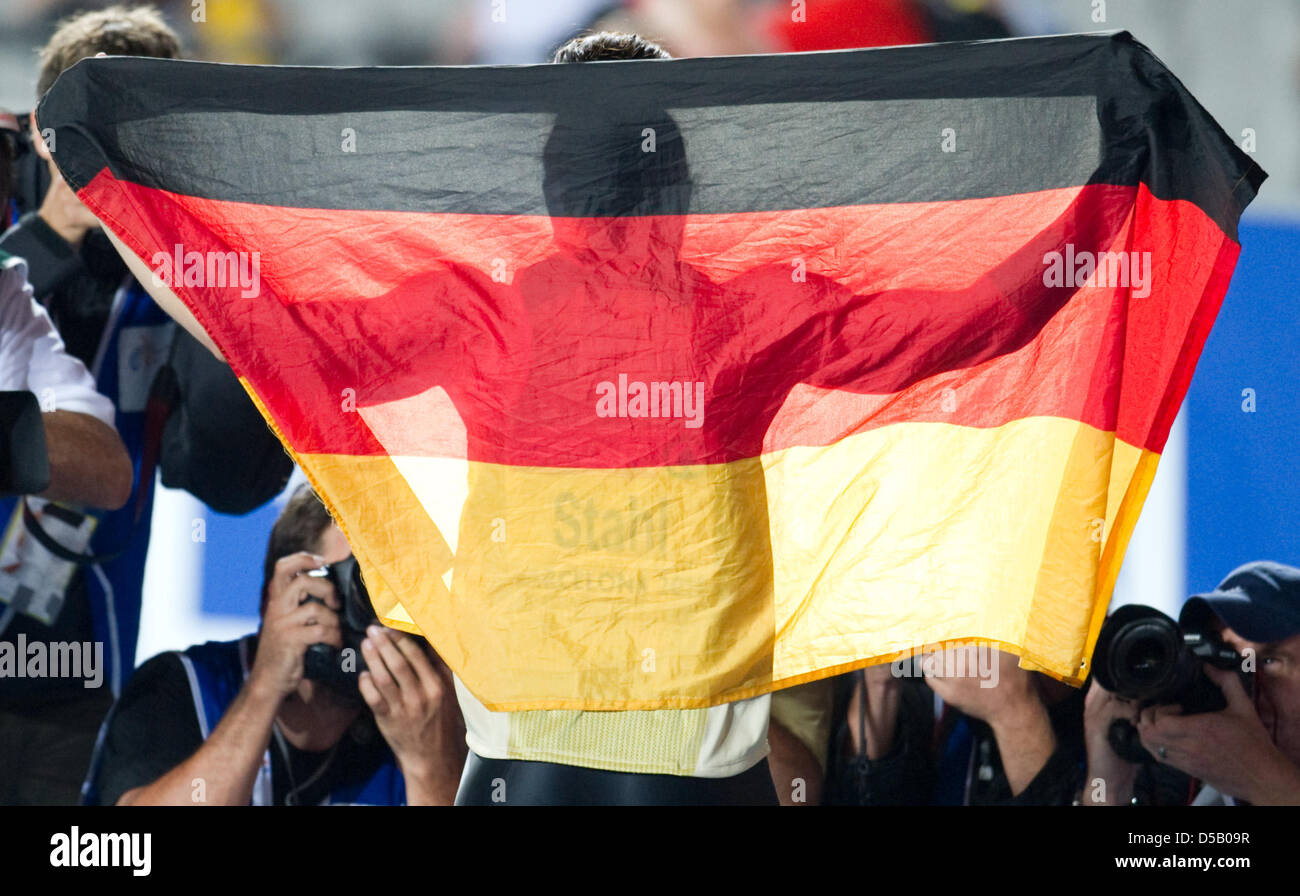 German javelin thrower Linda Stahl holds up a German flag at the Olympic stadium Lluis Companys during the European Athletics Championships in Barcelona, Spain, 29 July 2010. Photo: Bernd Thissen Stock Photo