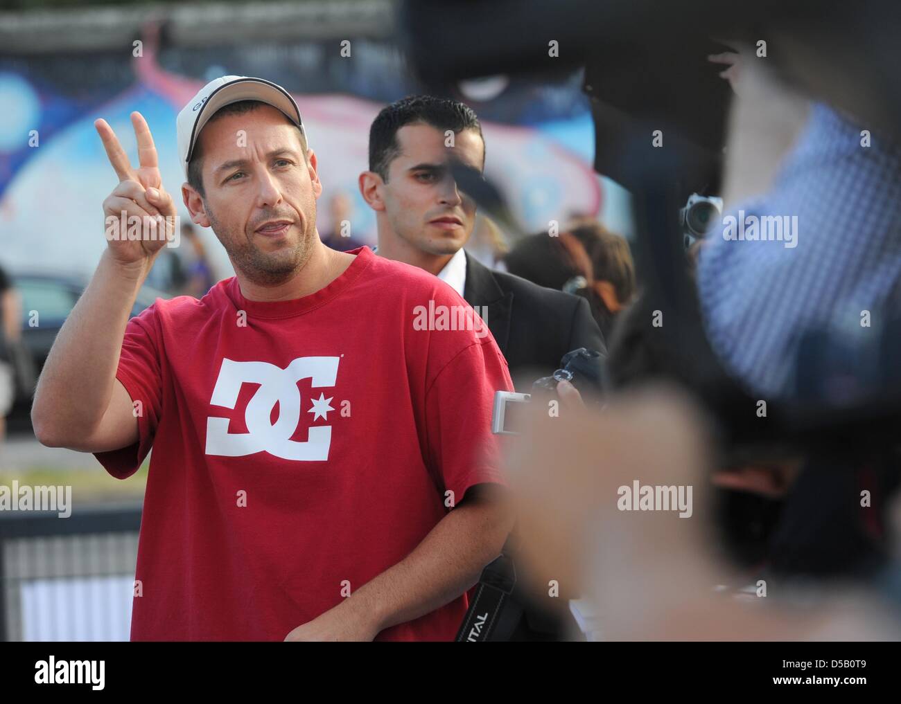 The actor Adam Sandler greets the photographers with a peace sign at the premiere of his film 'Grown Ups' in Berlin, Germany, 30 July 2010. The film is in German cinemans from 05 August on. Photo: Jens Kalaene Stock Photo