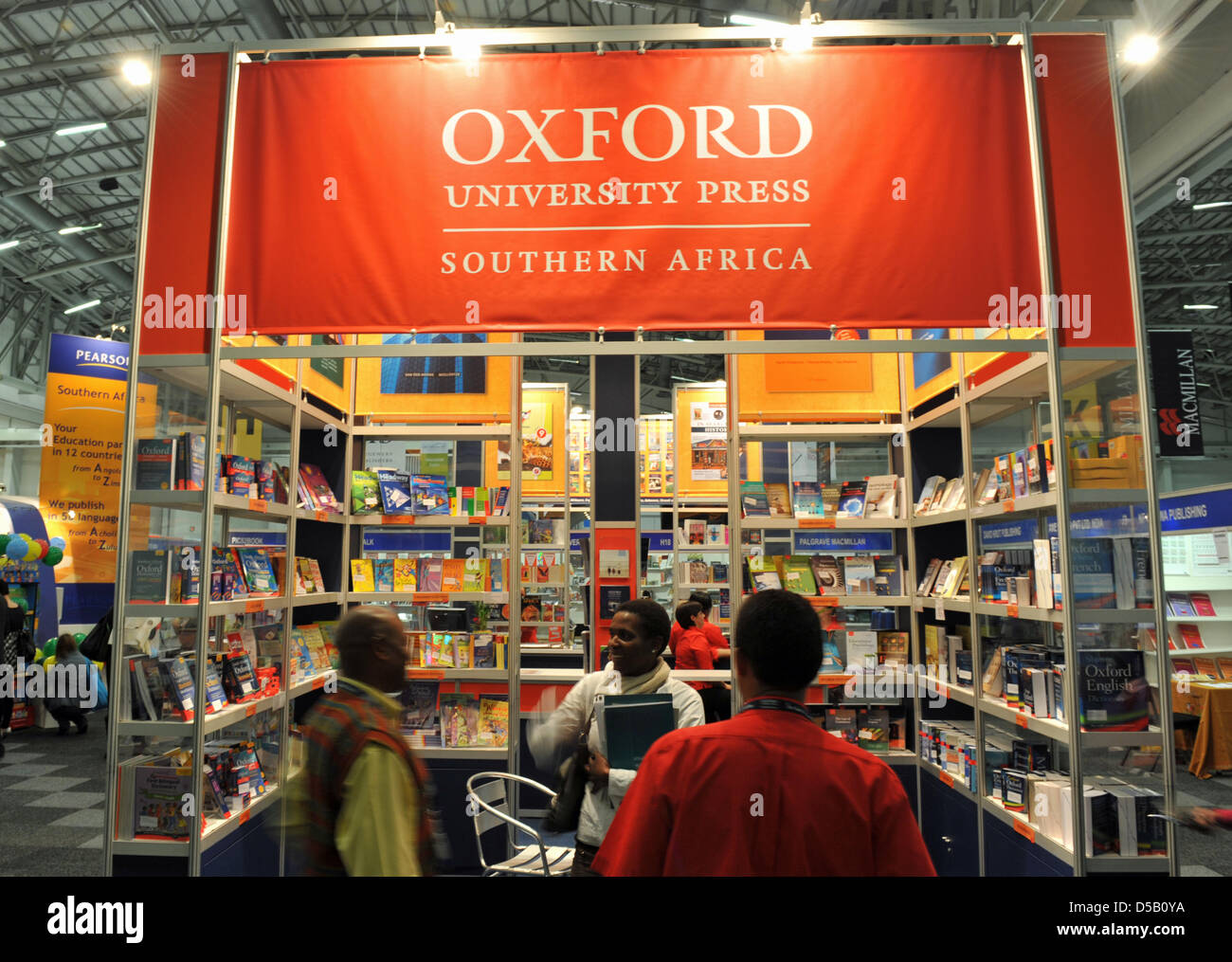 Shortly before the Cape Town Book Fair kicks off, people chat in front of the booth of the Southern Africa branch of Oxford University Press at the Convention Centre in Cape Town, South Africa, 30 July 2010. 273 exhibitors from 34 countries participate in South Africa's biggest international book fair. Photo: Ralf Hirschberger Stock Photo